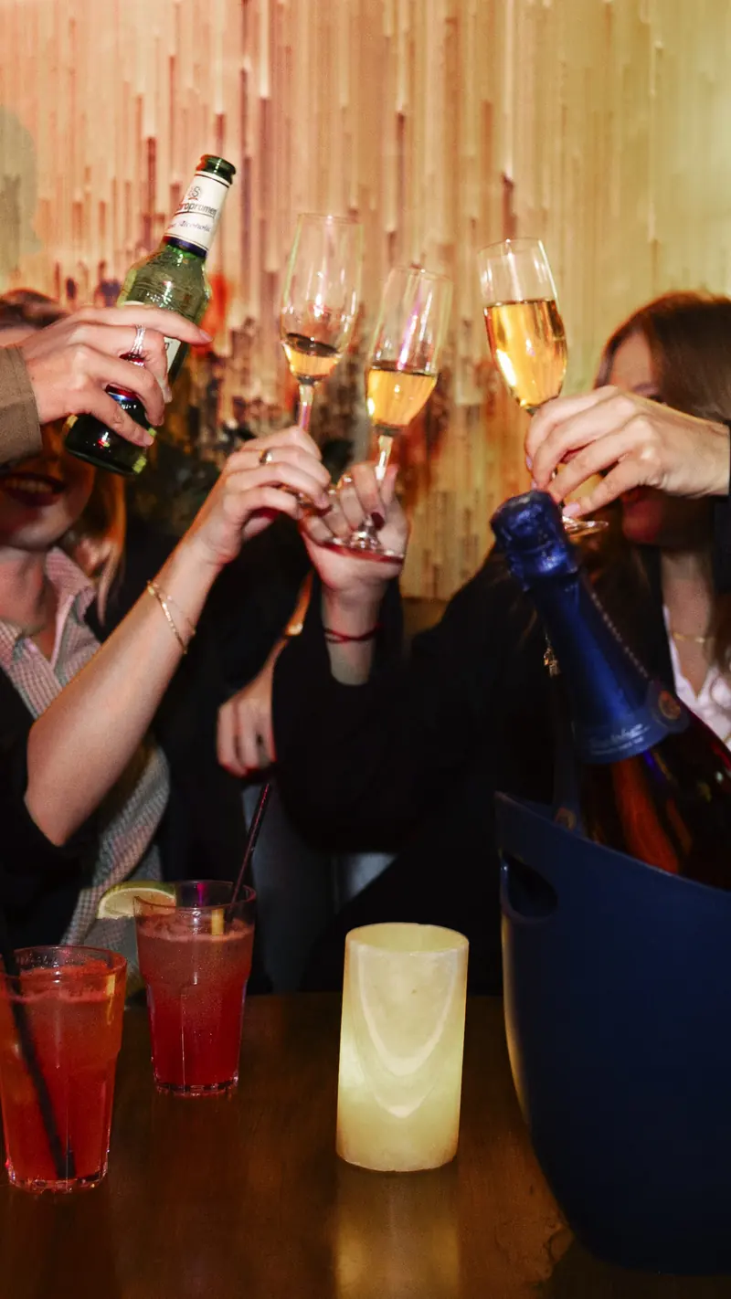 Vänner skålar i champagne runt ett bord