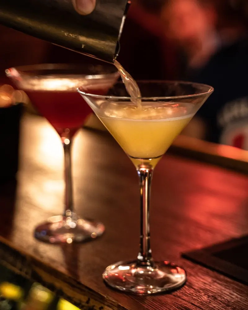 Två cocktails i martiniglas på bardisken
